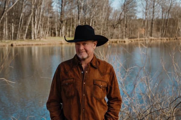 Tracy Lawrence standing in front of a lake